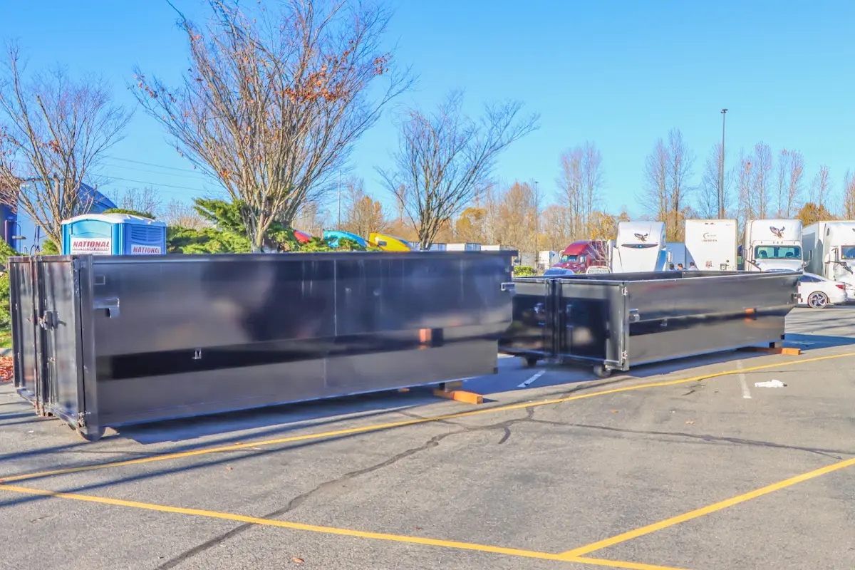 Professional dumpster rental service with roll-off container on residential driveway in East Pikeland